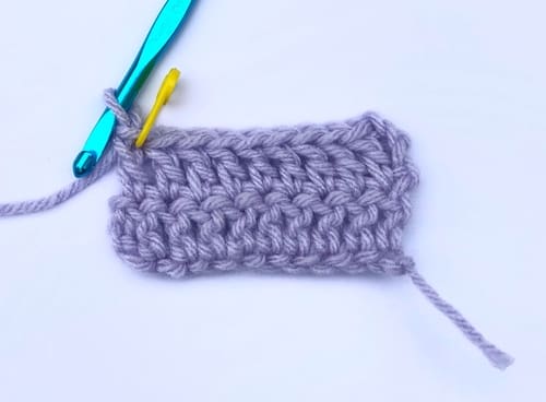 A stitch marker inserted into the last stitch of the row